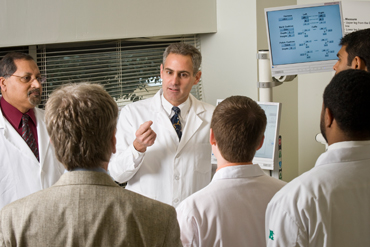 David X. Cifu, M.D., talking with colleagues