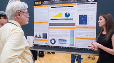 Student displaying her poster at Student Research Week